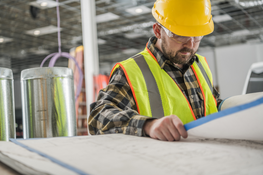 hvac construction technician checking blueprints