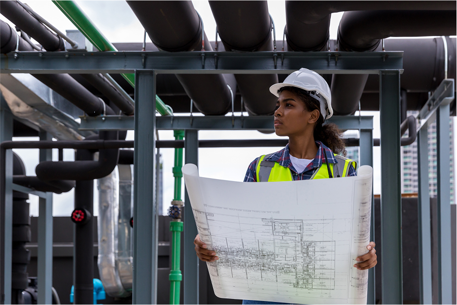 hvac technician interpreting blueprints on field